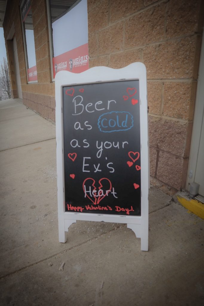 Bar sign at entrance. Beer as cold as your ex's heart.